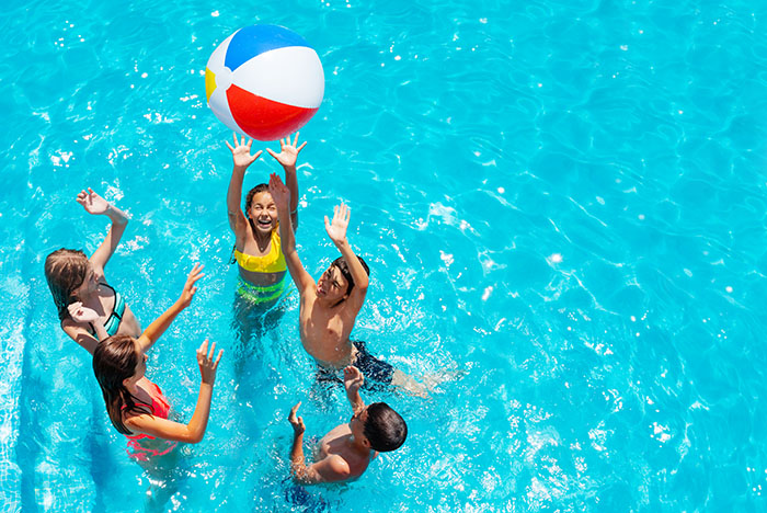 Kinder spielen im Wasser mit einem Wasserball