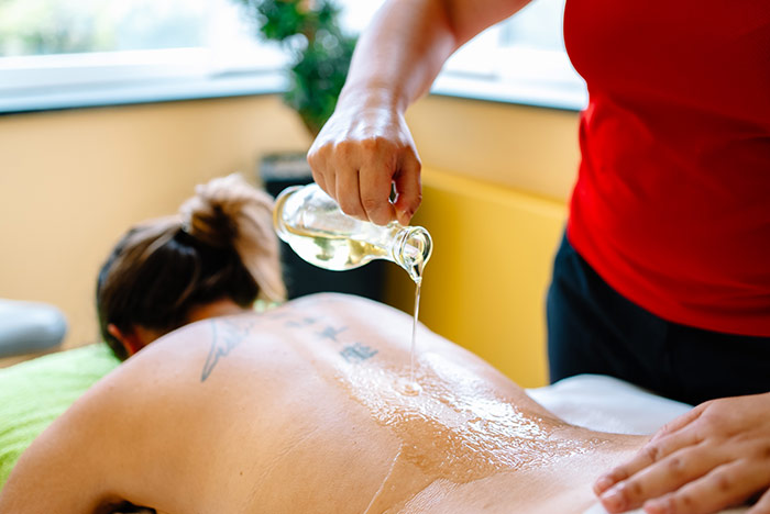 Frau bei der Klassischen Rückenmassage mit Aromaöl