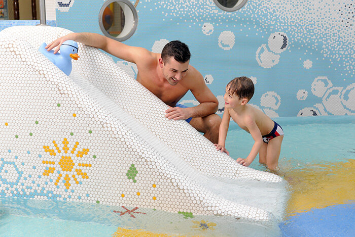 Vater und Sohn an der Kleinkindrutsche